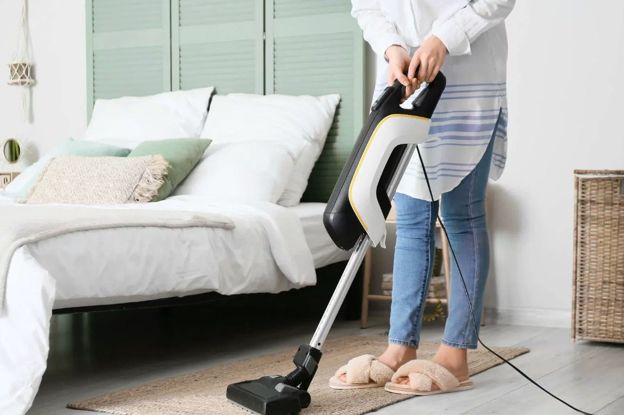 Vacuuming a bedroom during a recurring visit